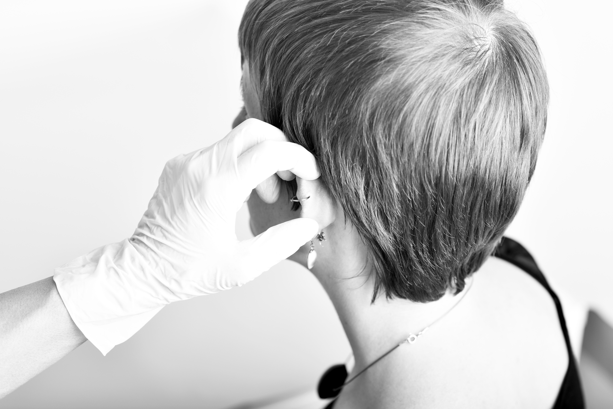 Une jeune femme se fait piercer l'oreille.